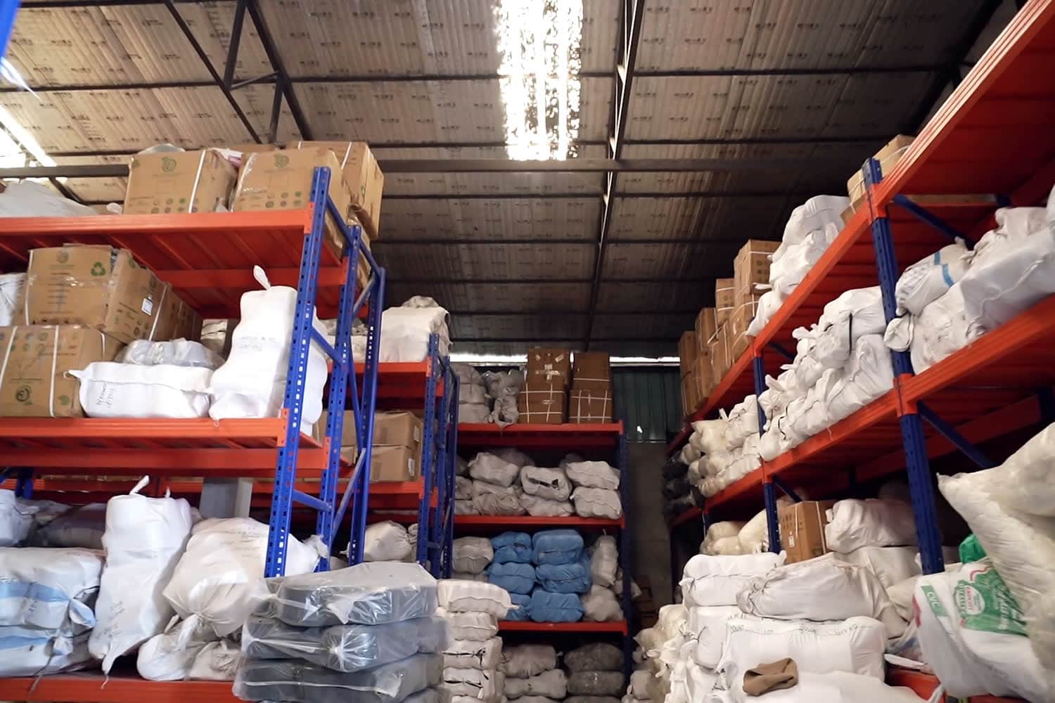 Rolls of cloth stacked on their ends in a warehouse, ready to move