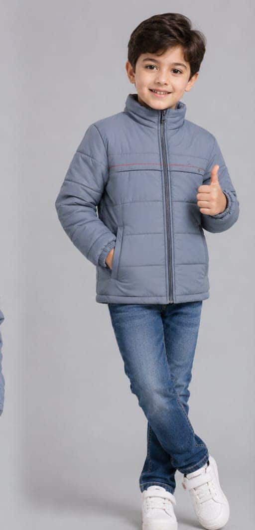 A boy in a grey padded jacket with a stand collar, worn with jeans