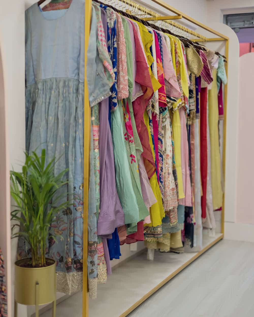 Kurtis and stitched sets along a boutique rail, a full run of colour